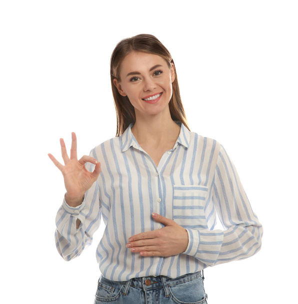 Healthy woman holding hand on belly and showing OK gesture against white background - Fotografie, Obrázek