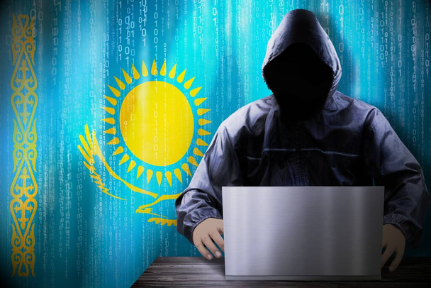 Anonymous hooded hacker, flag of Kazakhstan, binary code - cyber attack concept - Photo, Image