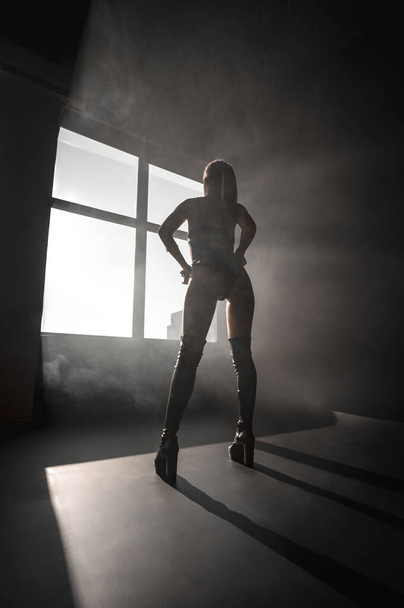 Sexy blonde in harness on a black cyclorama - Photo, image