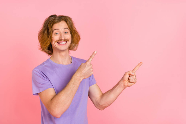 Portrait of attractive cheerful guy demonstrating copy blank empty space place isolated over pink pastel color background - Φωτογραφία, εικόνα