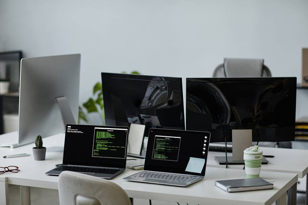 Werkplekken van diverse diversiteit programmeurs met laptops en computer monitoren - Foto, afbeelding