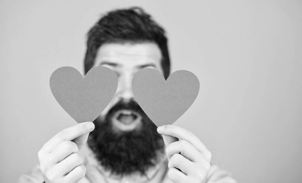 Man bearded hipster with heart valentine card. Celebrate love. Guy attractive with beard and mustache in romantic mood. Feeling love. Dating and relations concept. Happy in love. Love is amazing - 写真・画像