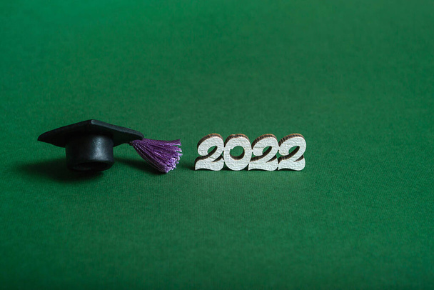Ballagási sapka és a 2022-es szám zöld háttérrel, fénymásoló felülettel. Orvosi oktatás koncepciója. - Fotó, kép
