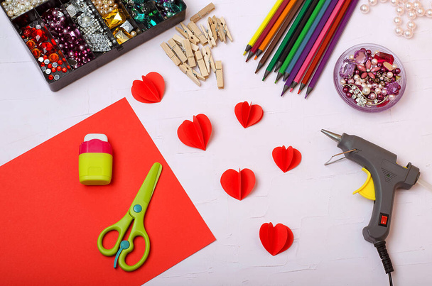 Valentine's Day. On a light background, colored pencils, pebbles, scissors, paper, glue, grater, oil can, heart patterns. Heart decor. Step by step instructions. Do it yourself. - Photo, Image