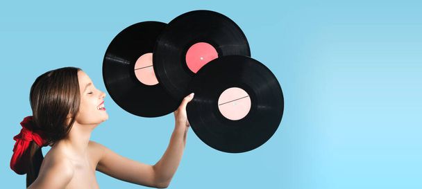 Cute happy girl holding in her hand three music records black color feeling good and relaxed, loves music. - Photo, Image