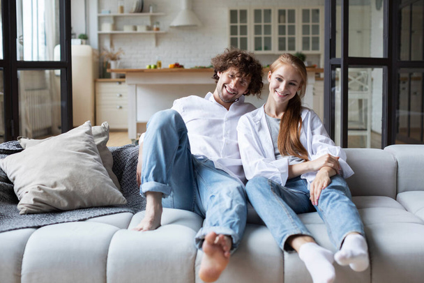 Portrait of a young loving couple resting on a couch. Enjoy together at home. - Foto, imagen
