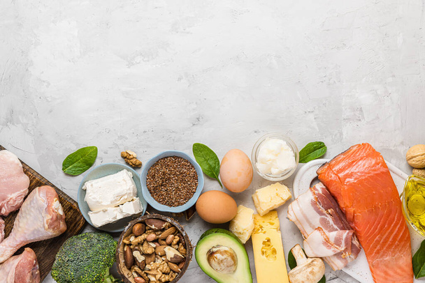 Gesunde Low-Carbs-Produkte mit gesunden Fetten. Keto-Diät. Fleisch, Fisch, Gemüse, Nüsse, Eier und Käse auf Betongrund. Ansicht von oben mit Kopierraum - Foto, Bild