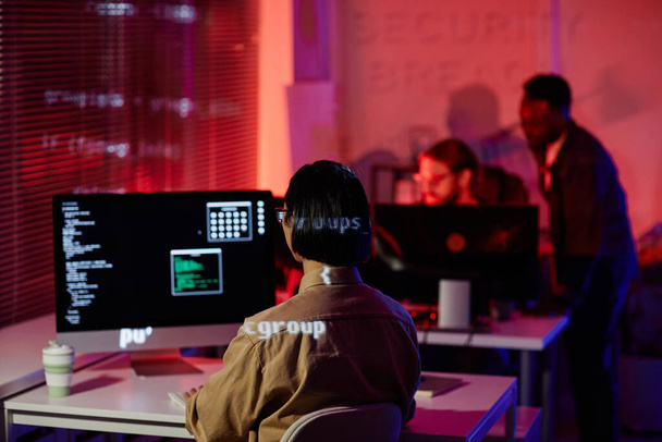 Rückansicht junger zeitgenössischer Programmierer vor Computerbildschirm - Foto, Bild