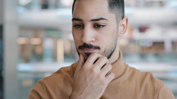 Fiatal zavarodott aggódó arab férfi komoly arckifejezéssel figyelmesen tartja a kezét az állán gondolkodás probléma megoldása gondolkodás ötlet megoldást talál megoldást talál kitalál tervet emel mutatóujj mosoly - Felvétel, videó