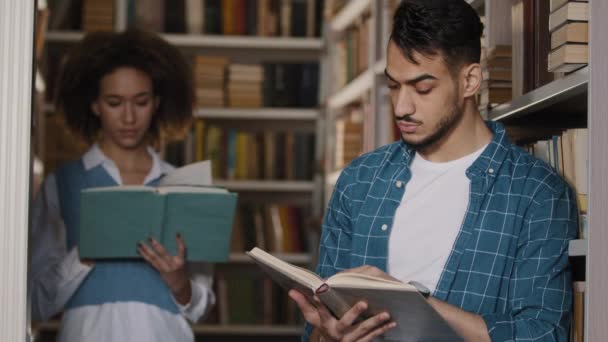 A diákok osztálytársak olvasni könyveket egyetemi könyvtár fiatal srác és lány tanulmány téma nem iskolai munka összpontosított középiskolás diák olvassa tankönyv irodalom házi feladat oktatás tanulás új ismeretek - Felvétel, videó