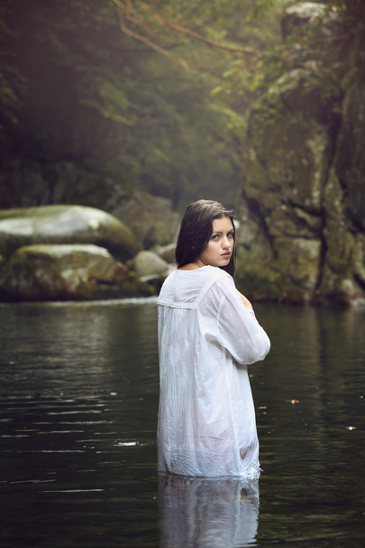 Beautiful woman posing in a mountain stream - Fotó, kép