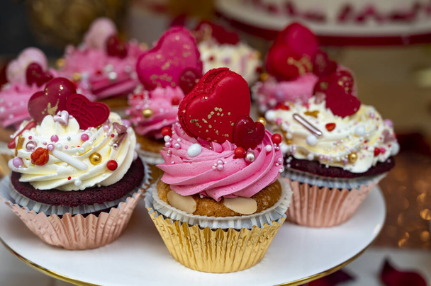 Πολύχρωμα διακοσμημένα cupcakes προς πώληση στο ζαχαροπλαστείο για να γιορτάσουν την ημέρα του Αγίου Βαλεντίνου κοντά - Φωτογραφία, εικόνα