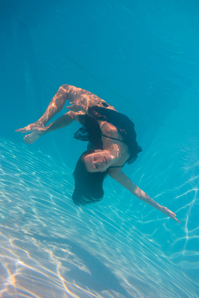 Young woman swimming undewater - Foto, Bild