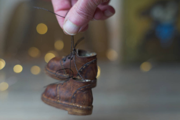 концепция легкой промышленности для производства стильной модной коричневой кожаной обуви с маленькими ножками для плюшевых мишек или кукол, а также для детей и их родителей - Фото, изображение