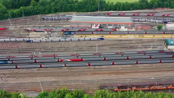 夏の間の鉄道駅や鉄道線路の空中ドローン映像は、リーズ西ヨークシャーのオズモンソープの村のトラックに多くの列車を示しています英国 - 映像、動画