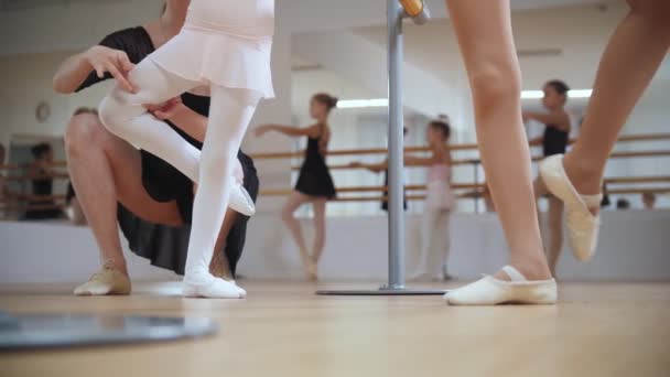 Entrenamiento de ballet - niñas entrenando su baile en zapatos puntiagudos con la ayuda de su entrenador - Imágenes, Vídeo