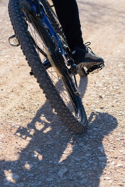 Mountain bike ride on a stone road. Close-up of the rear wheel. - Photo, Image