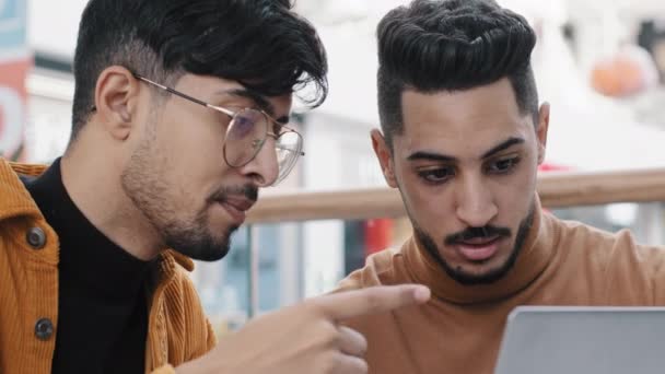 Deux jeunes gars arabes amis bavarder en regardant l "écran d" ordinateur portable rendant l "ordre dans la boutique en ligne en utilisant une nouvelle application informatique médias sociaux bavarder sur sortir ensemble site parcourir l" apprentissage à distance Internet surf - Séquence, vidéo