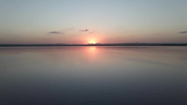 Piękny zachód słońca nad spokojnym jeziorem w Las Salinas de Torrevieja w prowincji Alicante w Hiszpanii. Szeroki strzał. - Materiał filmowy, wideo