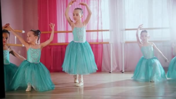 Malé baletní dívky v modrých šatech se připravují na trénink ve studiu - Záběry, video