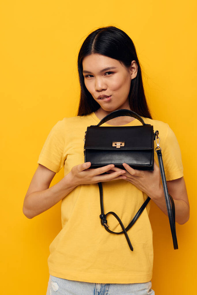 woman female clutch accessories posing yellow background unaltered - Zdjęcie, obraz