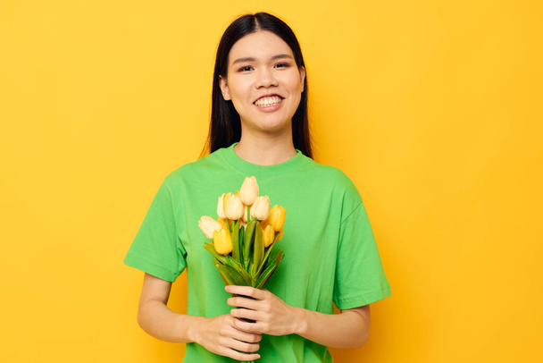 pretty brunette green t-shirt a bouquet of yellow flowers isolated background unaltered - Foto, immagini