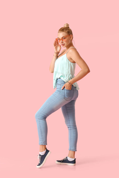 Fashionable young woman in stylish jeans on color background - Foto, Bild