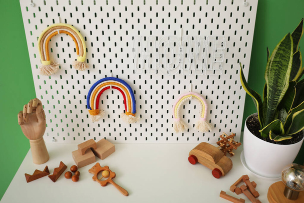 Skrzynia z szufladami z pekturą i zabawkami w pobliżu zielonej ściany - Zdjęcie, obraz