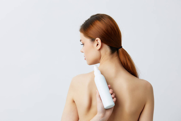 pretty woman  with skin care lotion on  Gray background. High quality photo - Фото, зображення
