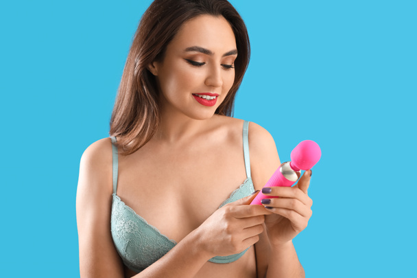 Young woman with vibrator from sex shop on color background - Fotó, kép