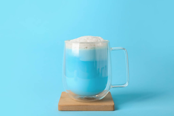 Стеклянная чашка синего маття латте на цветном фоне - Фото, изображение