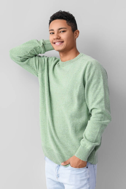 Handsome African-American guy in knitted sweater on light background - Photo, image
