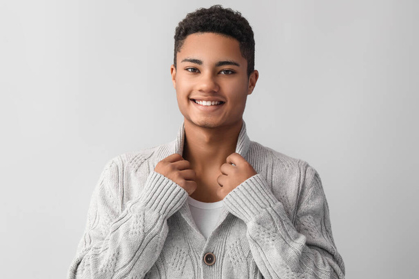 Handsome African-American guy in knitted sweater on light background - Fotografie, Obrázek