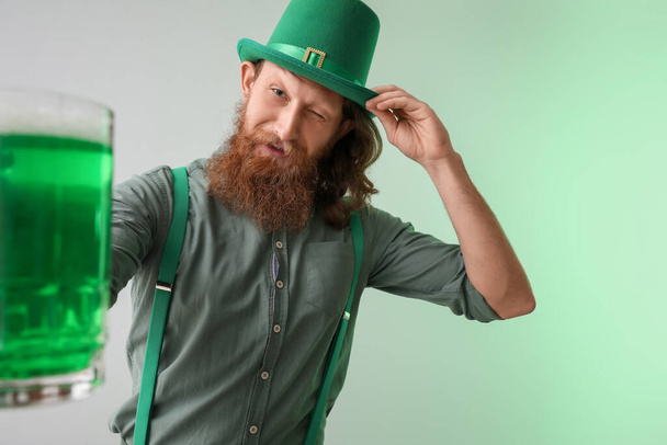 Happy bearded man with glass of beer on light background. St. Patrick's Day celebration - Valokuva, kuva