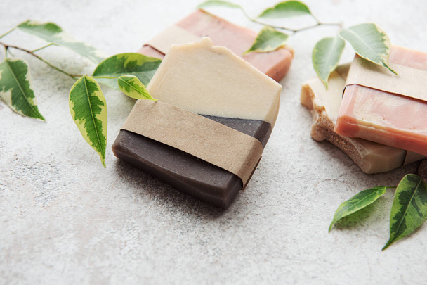 Assorted handmade soap bars and green leaves  - Photo, Image