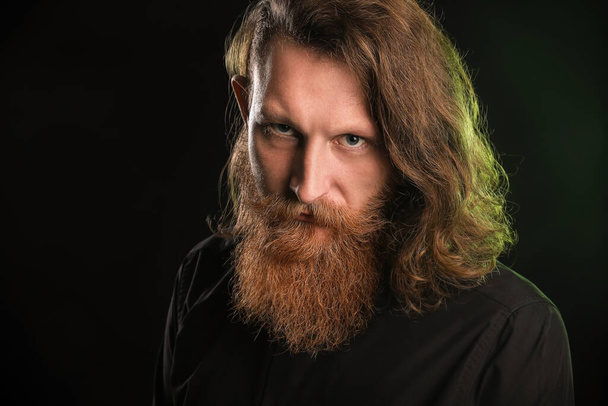 Portrait of young bearded man on black background - Photo, Image