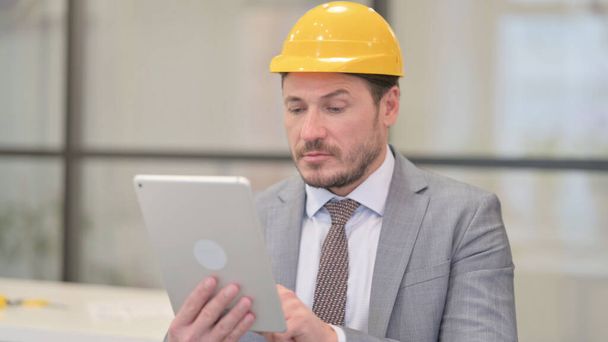Porträt eines attraktiven Ingenieurs mittleren Alters mit Tablet im Büro - Foto, Bild
