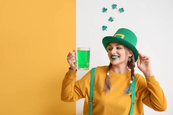Young woman with glass of beer and decor for St. Patrick's Day on color background - 写真・画像