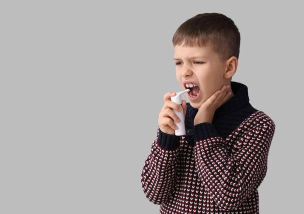 Kranker kleiner Junge mit Inhalator auf grauem Hintergrund - Foto, Bild