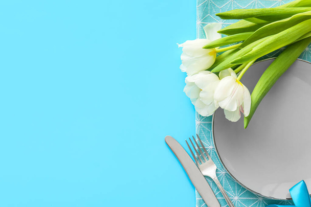 Elegante mesa con flores de tulipán sobre fondo azul - Foto, imagen