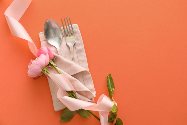 Stylish cutlery with flowers on coral background - Фото, зображення