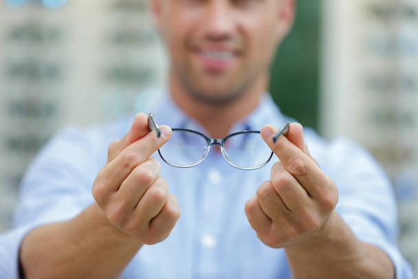 man with glasses showing something - Zdjęcie, obraz