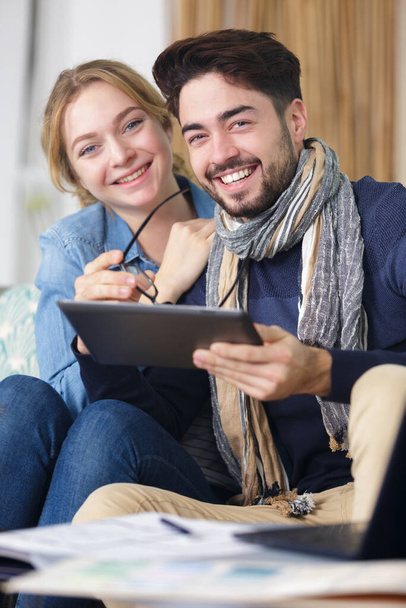 happy couple with laptop spending time together at home - Фото, зображення