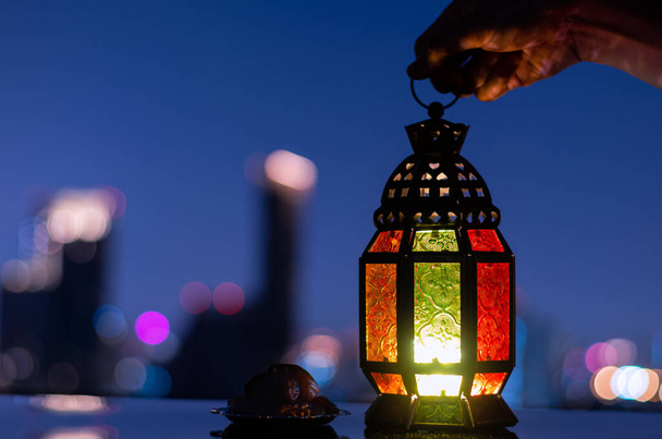 Lantern a malý talíř data ovoce s městským pozadím pro muslimské svátky svatého měsíce ramadán Kareem. - Fotografie, Obrázek