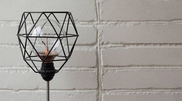 електрична лампа з металевим абажуром на білій цегляній стіні
 - Фото, зображення