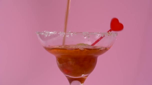 Cóctel de San Valentín con fresa en vaso de martini sobre fondo rosa - Metraje, vídeo