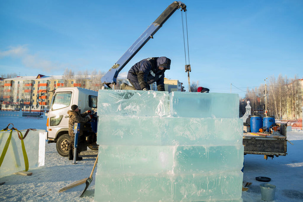 Monteurs lossen ijsplaten uit een auto met behulp van een kraan - Foto, afbeelding