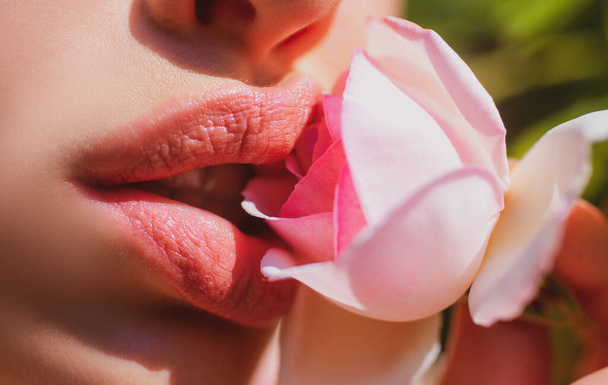 Closeup beautiful woman lips with natural lipstick. Open mouth with rase. Cosmetology, fashion makeup concept. Beauty passionate kiss flowers. - Foto, Imagen
