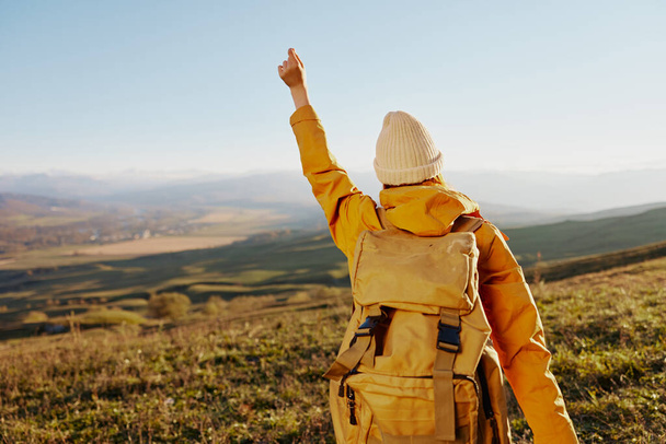 voyageur femme en veste jaune dans un sac à dos chapeau montagnes Voyage air frais - Photo, image