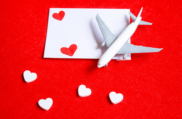 Καρδιές και ένα αεροπλάνο σε κόκκινο φόντο. Ημέρα του Αγίου Βαλεντίνου. Επιλεκτική εστίαση. - Φωτογραφία, εικόνα